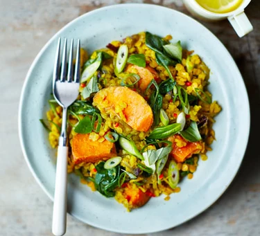 A plate with a serving of spinach, sweet potato and lentil dhal