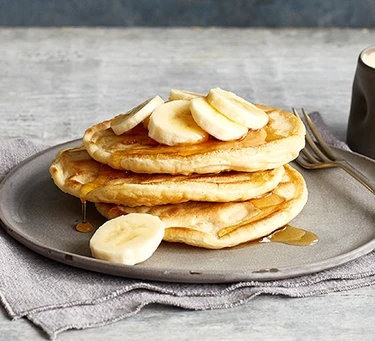 A plate of pancakes with banana